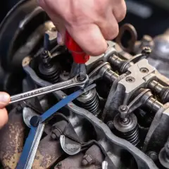 Mechanik reguluje zawory silnika, używając klucza i szczelinomierza. Precyzyjna regulacja zapewnia optymalne działanie, zgodnie z tabelą luzów zaworowych.