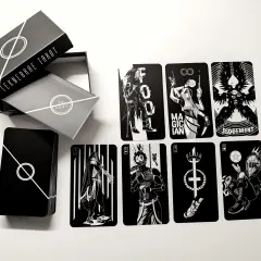 Czarno-białe karty z talii tarot z 5 kartami, w tym Mag, Sąd i inne postacie. Pudełko z napisem "TEKNEBRAE TAROT".