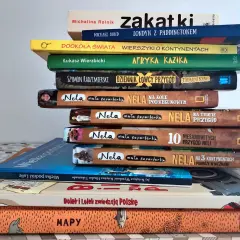 Stos książek o podróżach, w tym "Dookoła świata" i "Afryka Kazika", zachęca do odkrywania świata.