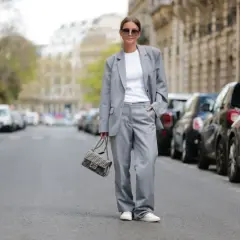Elegancki damski garnitur w stylu smart casual, biały top, sneakersy i torebka Fendi.