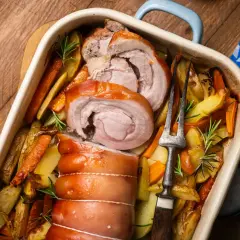 Saftiger **Rollbraten im Backofen** mit knusprigen Kartoffeln und Karotten, garniert mit Rosmarin. Ein Festmahl!
