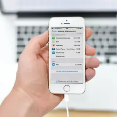 Mano sujetando un iPhone mostrando la gestión de almacenamiento, útil para la copia de seguridad iPhone.
