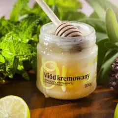 Słoik z miodem kremowanym, drewniana łyżka, świeża mięta, limonka i zioła. Idealny dodatek do herbaty.