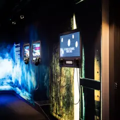 Utställning på Avicii museum med skärmar och hörlurar. En skärm visar texten "IF THOSE LISTENERS WERE EGGS".