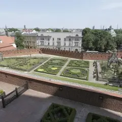 Krakowski ogród z geometrycznymi rabatami i architekturą, przypominający o dawnych czakramach w Polsce.