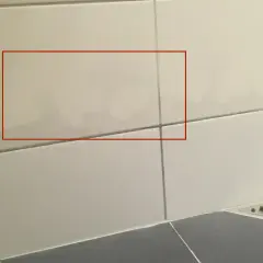 Fuktskada badrum tecken syns som mörka fläckar på kaklet. Vatten har trängt in.