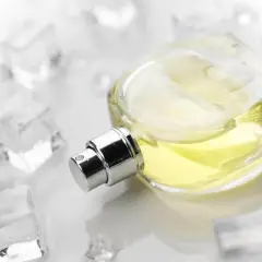 Eleganckie szyprowe perfumy w szklanej butelce, otoczone kostkami lodu, sugerują orzeźwiający, chłodny zapach.