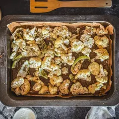 Goldbrauner blumenkohl im backofen, knusprig und aromatisch, bereit zum Genießen. Daneben ein Stück Käse und ein Dip.