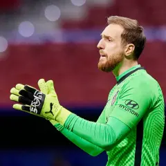 Jan Oblak, bramkarz Atletico Madryt, w zielonej koszulce, z rękami gotowymi do obrony.