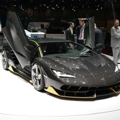 Ciemnoszary Lamborghini z otwartymi drzwiami, żółtymi akcentami. Zastanawiasz się, ile kosztuje Lamborghini? Ten model robi wrażenie!