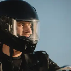 Hombre con casco de moto negro, listo para la aventura. Su mirada refleja la libertad y la seguridad que ofrece la homologación DOT.