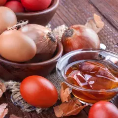 Jajka, cebula i łuski cebuli na drewnianym stole, przygotowanie do naturalnego barwienia.