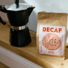 Czarna kawiarka i paczka kawy bezkofeinowej "DECAF" od JAVA Coffee Roasters. Idealny zestaw na poranną kawę z kawiarki.
