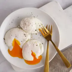 Trois œufs pochés parfaits, avec leurs jaunes coulants, assaisonnés de poivre noir. Un délice de différents types d'œufs pour un petit-déjeuner gourmand.