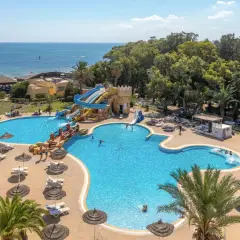Basen z wodnymi zjeżdżalniami i palmami przy hotelu Marhaba Royal Salem.