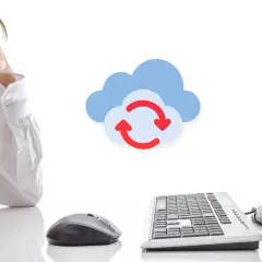 Hombre frustrado frente a un ordenador, con un icono de nube y flechas que indican que es sincronizar datos.