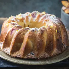 Szybka babka wilgotna, ozdobiona cukrem pudrem i skórką cytrynową, wygląda apetycznie.