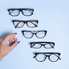 Dłoń wybiera okulary. Czy to będzie ta para, na którą czekałam, by zrealizować recepta na okulary NFZ?