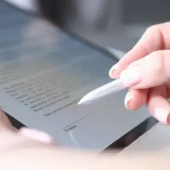 Dłoń z długopisem elektronicznym podpisuje dokument na ekranie, potwierdzając swoją zdolność do czynności prawnych.