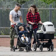 Maciej Zakościelny z żoną i dwójką dzieci spacerują. Jeden maluch w wózku, drugi w gondoli.