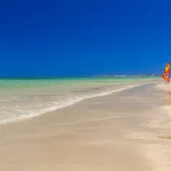 Piękna plaża w Tunezji w czerwcu. Idealna pogoda na windsurfing, trzy kolorowe żagle czekają na wiatr.