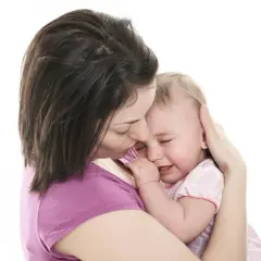Matka tuli płaczące dziecko, martwiąc się o jego choroba stilla objawy.
