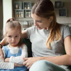 Zła dziewczynka siedzi z matką, która próbuje ją pocieszyć. Czasem nie mam cierpliwości do dziecka.