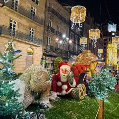 Papá Noel y un reno cubierto de nieve junto a árboles de Navidad adornados con luces. Las calles de Vigo brillan con la magia de la Navidad.
