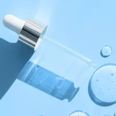Droppe av serum med hyaluronsyra och retinol på blå bakgrund.