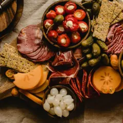 Deska serów i wędlin z owocami kaki, oliwkami i piklami. Idealna na wino aperitif.