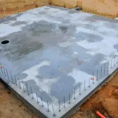 Gotowa płyta fundamentowa, zbrojenie wystające z betonu. Warto sprawdzić płyta fundamentowa koszt, by zaplanować budowę.