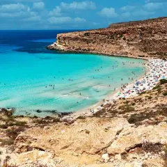Spiaggia con acque cristalline e scogliere, un vero gioiello per la classifica delle spiagge più belle del mondo.
