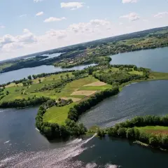 Malowniczy kółko raduńskie z lotu ptaka, otoczone jeziorami i zielonymi polami.