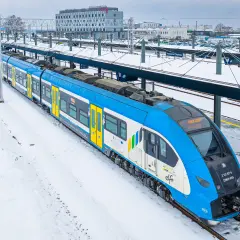 Pociąg Kolei Śląskich "Elf" na śnieżnym peronie Pyrzowice Lotnisko.