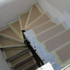Schody zabiegowe w trakcie budowy, z widocznymi stopniami i taśmą zabezpieczającą. Jak obliczyć schody zabiegowe?
