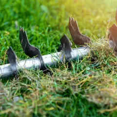 Metalowe ostrza wertykulatora zagłębiają się w trawnik, przygotowując go do wiosennego wzrostu. To idealny moment, kiedy wertykulować trawnik na wiosnę.