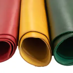 Trois rouleaux de cuir végétal aux couleurs vives : rouge, jaune et vert. Parfait pour vos créations artisanales.