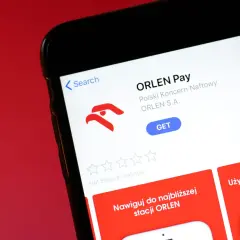 Aplikacja ORLEN Pay na ekranie telefonu. Umożliwia nawigację do stacji ORLEN i płatności.