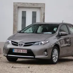 Szary Toyota Auris 1.6 benzyna zaparkowany obok rzeźby.