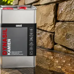 Metalowa puszka z napisem "Dynasil Kamień" obok mokrej kamiennej ściany. To nowoczesny impregnat hydrofobizujący do kamienia naturalnego.