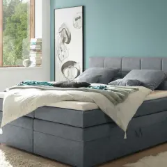 Ein Schlafzimmer mit einem Boxspringbett in Grau und einer Wand in Türkis. Tolle wandfarben ideen für ein maritimes Flair.