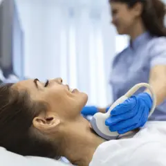 Badanie USG szyi, kluczowe dla diagnostyki tarczycy. Lekarz wykonuje badanie, by ocenić stan tarczycy, a jod jest ważnym pierwiastkiem dla jej prawidłowego funkcjonowania.