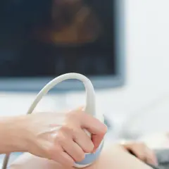 Badanie USG wykazało u płodu małogłowie. Lekarz wykonuje badanie, by ocenić rozwój dziecka.
