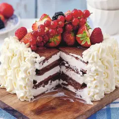 En chokladtårta med lager av grädde och bär, toppad med färska jordgubbar, hallon och vinbär. Dessa goda tårtor ser fantastiska ut!