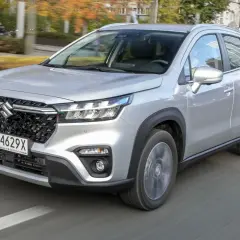 Srebrny Suzuki S-Cross w ruchu miejskim. Wiele osób szuka **suzuki s-cross opinie** przed zakupem.