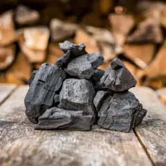Holzkohle auf Holz, ein Ergebnis der Verkohlung von Holz, zeigt, wie Holzkohle hergestellt wird.