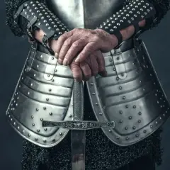 Rycerz w zbroi trzyma miecz. Może szukać bannerlord cheats, by zdobyć przewagę w bitwie.