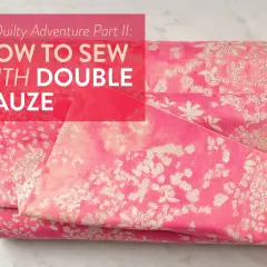 A pink floral double gaze de coton fabric is folded, with text overlaying the image.