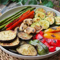 Una colorida parrillada de verduras: espárragos, zanahorias, champiñones, calabacín, berenjena y pimientos asados a la perfección.