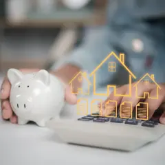 Une tirelire et une calculatrice avec des icônes de maisons et de documents. Une autre solution que le prêt relais pour financer votre projet immobilier.
